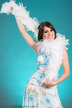 Séance de photo portrait sur fond turquoise avec boa blanc par un photographe